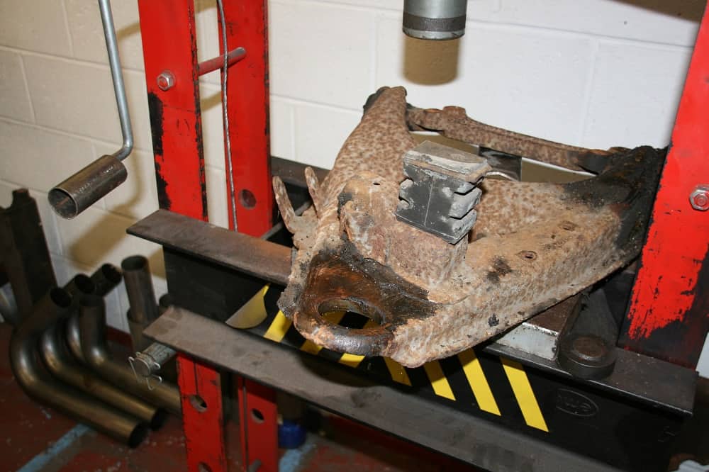 An old bottom ball joint with a holed dust cover.